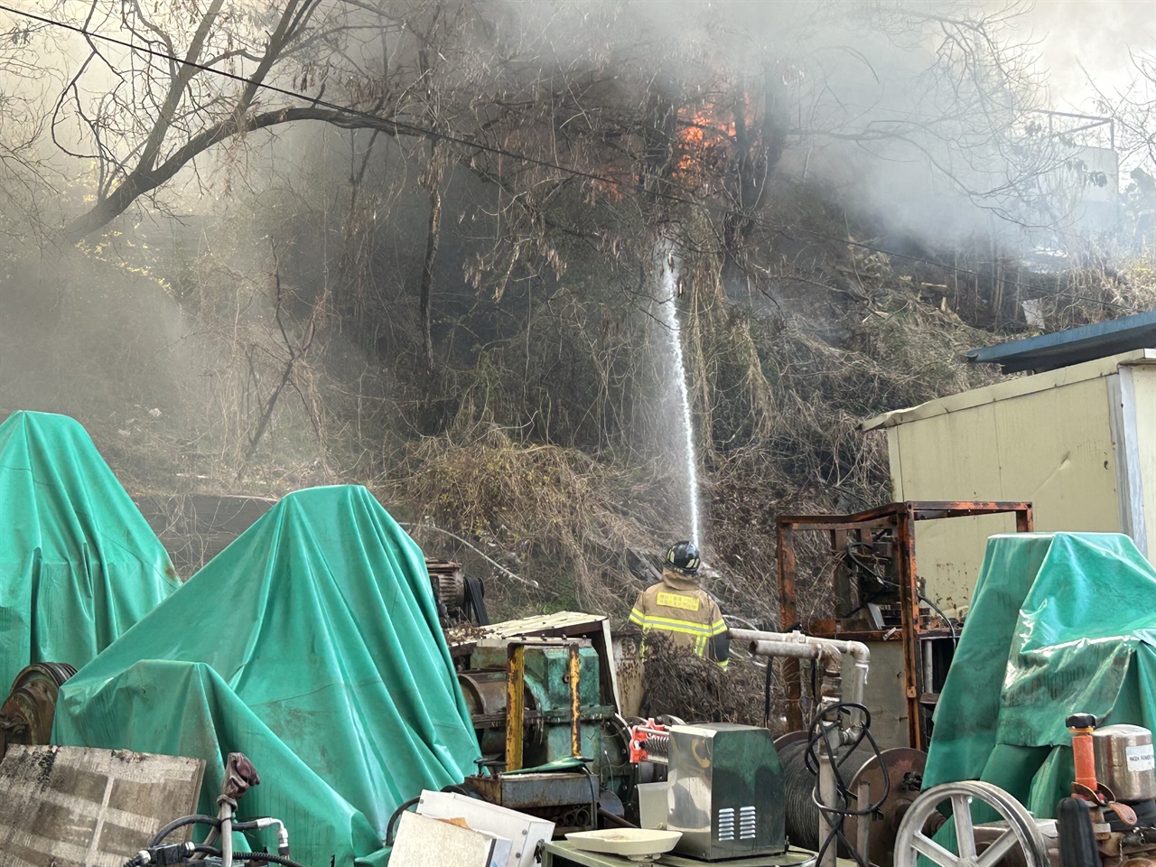 인근 공장으로 불이 번질 위험에 대비해 소방관들은 주변에 물을 뿌리고 있다.