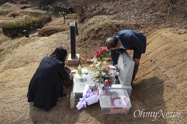 고 안지호씨 묘에 도착한 부모님이 묘비를 닦고 준비한 음식을 꺼내고 있다.