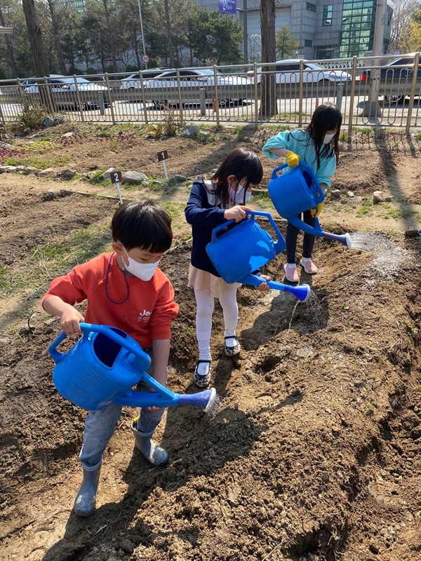 서울 마포구의 상암두레텃밭에서 어린이들이 농작물에 물을 주고 있다.