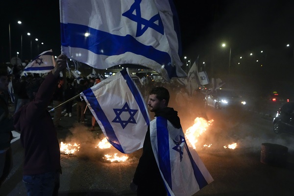 2023년 3월 27일 이스라엘 베이트 야나이 인근에서 시위대가 타이어를 태우고 있다. 이날 시위엔 베냐민 네타냐후 총리의 사법개혁안에 반대하는 이스라엘 시민 수만 명이 집결했다.

