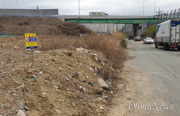 김해 장유율하 남해고속도로 제2지선 주변에 버려진 쓰레기가 수거된 뒤 안내팻말이 세워져 있다.