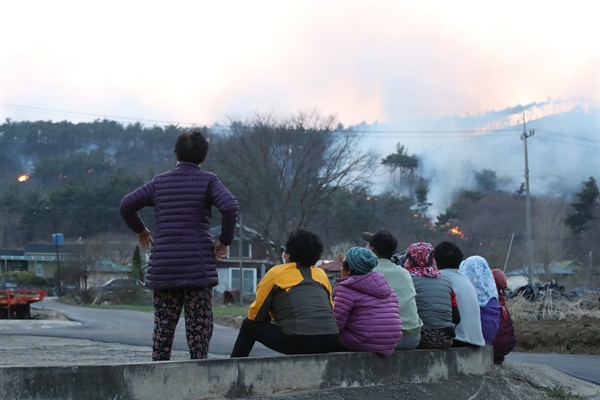 2일 오전 11시께 충남 홍성군 서부면에서 발생한 산불이 8시간 넘게 계속되자, 마을 주민들이 걱정하며 산불을 바라보고 있다.