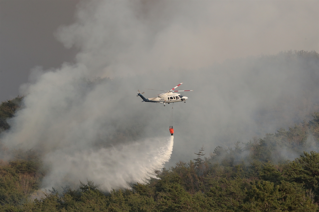 3일 오후 전남 함평군 대동면 연암리 한 야산에서 불이 나 산불 진화 헬기가 물을 뿌리고 있다.