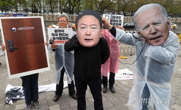 전국민중행동 관계자들이 4월 11일 오후 서울 용산구 대통령실 인근에서 기자회견을 열고 미국 중앙정보국이 한국 정부에 불법 도청하고 있는 행위를 재연하는 퍼포먼스를 하고 있다.