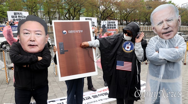  전국민중행동 관계자들이 11일 오후 서울 용산구 대통령실 인근에서 기자회견을 열고 미국 중앙정보국이 한국 정부에 불법 도청하고 있는 행위를 재연하는 퍼포먼스를 하고 있다.
