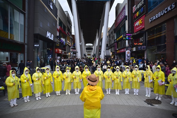  JYM 커뮤니티 멤버들이 노란 우비를 함께 입고 나와 세월호 참사를 추모하는 플래시 몹을 준비하고 있다.