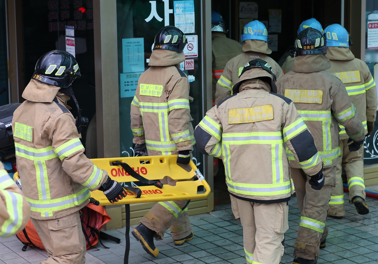  19일 오후 전남 화순군 화순읍 한 요양병원 지하에서 화재가 발생해 소방대원들이 환자를 옮기기 위해 들것을 들고 이동하고 있다.