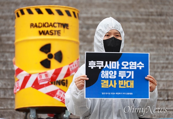 일본 정부가 후쿠시마 원전 오염수의 방류에 나서겠다고 밝히자 이를 비판하는 목소리가 이어진다. 지난달 25일 방사성 물질이 담긴 오염수를 상징하는 드럼통 앞에서 손팻말을 들고 시위 중인 한 환경단체 회원. 