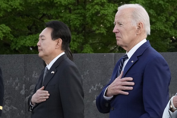 윤석열 대통령과 조 바이든 대통령이 2023년 4월 25일 워싱턴DC에 있는 한국전 참전용사 기념관에 헌화한 뒤 용사들을 기리고 있다. 