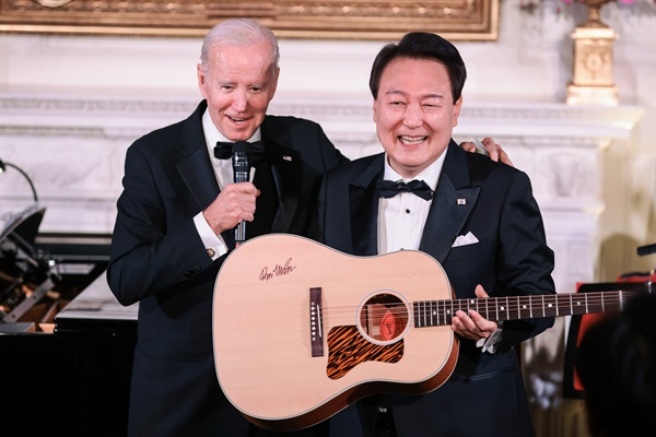 2023년 4월 26일 워싱턴 DC 백악관 이스트룸에서 열린 국빈만찬에서 조 바이든 미국 대통령이 주최하는 가운데 대한민국 윤석열 총장이 돈 맥클린의 사인이 담긴 어쿠스틱 기타를 들어보이고 있다.