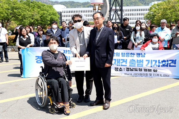 최진기 경남장애인차별철폐연대 공동대표가 28일 경남도청 정문 앞에서 강순익 경남도 장애인복지과장한테 건의문을 전달하고 있다.