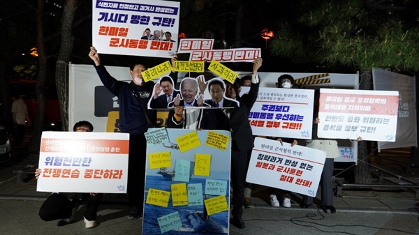 5월 3일 서울 보신각 앞에서 열린 수요평화촛불에서 참가자들이 ‘기시다 방한 규탄’과 ‘한미일 군사동맹 반대’ 등의 피켓을 들고 있다.