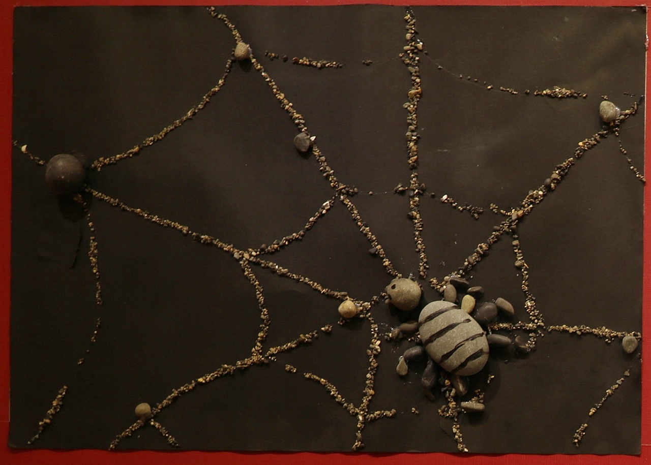 해변의 몽돌과 모래를 재료로 만든 거미와 거미줄(섬마을 아이들과 함께 만들었다고 한다)