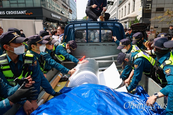 ’10.29이태원참사 200일, 200시간 집중추모행동 주간’ 관련 집회물품은 실은 차량이 국민의힘 당사 앞에 도착한 가운데, 경찰이 물건 내리는 것을 제지하고 있다. 