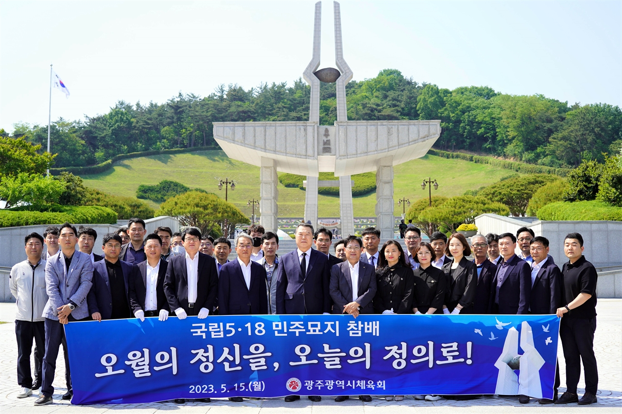 광주광역시체육회 전갑수 회장과 임직원들이 15일 오후 북구 운정동 국립 5·18민주묘지 참배를 마친 뒤 ‘오월의 정신을, 오늘의 정의로!’ 현수막을 펼쳐 보이고 있다.