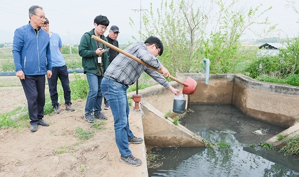 충남 예산군청 공무원이 축산폐수를 배출한 농수로에서 시료를 채취하고 있다.