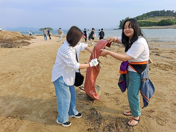  양식생물학과 김나은(오른쪽)씨가 해양쓰레기를 주우며 어촌이나 양식장에서 발생하는 어구나 플라스틱을 환경친화적 제품으로 바꿔야 한다고 말했다. 