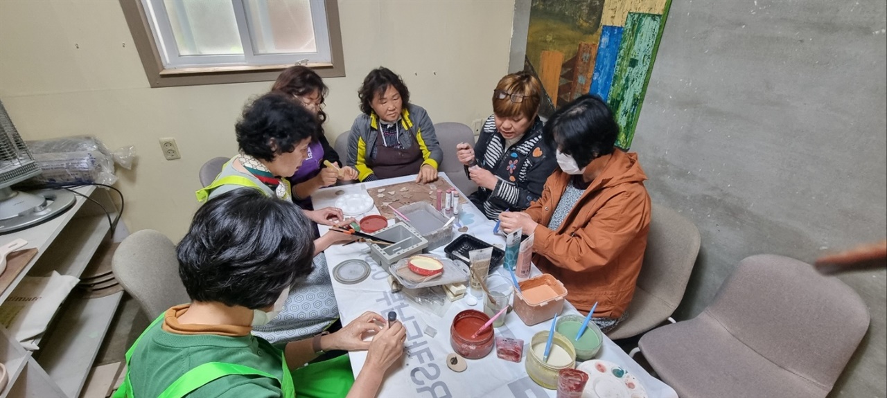 역전시장 입주예술인 신구경(55)씨가 지역주민들에게 찰흙으로 브로치를 만드는 방법을 설명하고 있다.