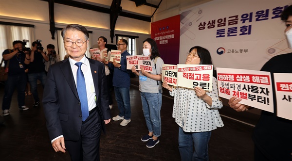 23일 오후 서울 중구 정동1928아트센터에서 열린 상생임금위원회 토론회에 이정식 고용노동부 장관이 참석한 가운데 비정규직 임금 대폭 인상, 노동시장 이중구조 해결 등을 촉구하는 기습시위가 진행되고 있다.