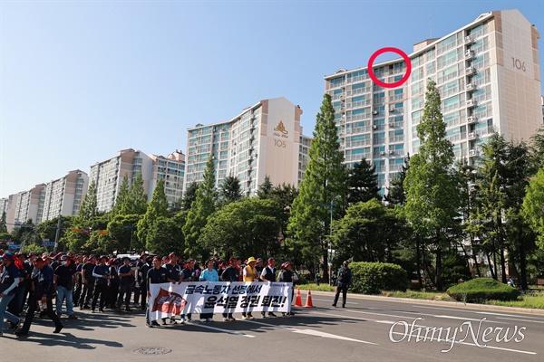 금속노조 경남지부가 5월 31일 오후 창원 만남의광장 앞에서 집회를 열었을 때 건너편 아파트 꼭대기층에서 경찰관이 캠코더로 촬영하고 있다(원안).
