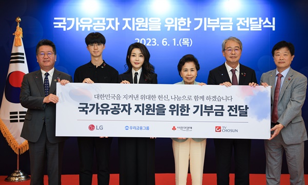 김건희 여사가 1일 서울 중구 사랑의열매 회관에서 열린 국가유공자 지원을 위한 기부금 전달식에서 참석자들과 기념촬영을 하고 있다.