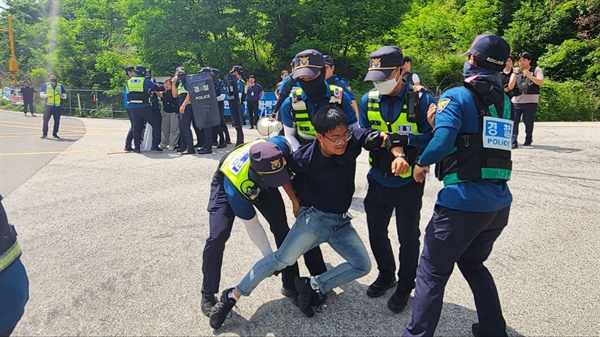 화력격멸훈련 중단을 촉구하며 승진훈련장 앞으로 뛰쳐나간 학생이 경찰에 의해 거세게 끌려나가고 있다.