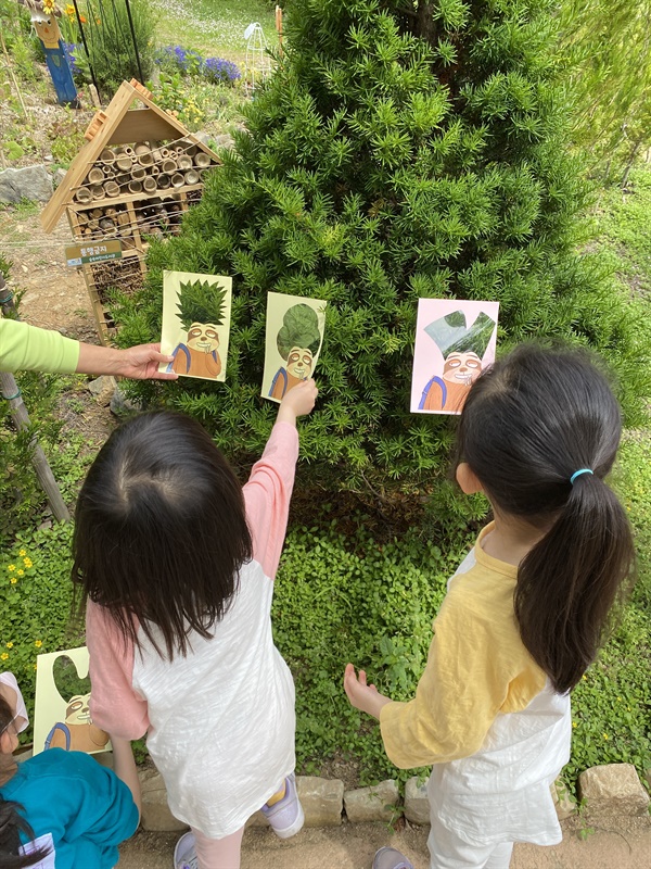야외에서 자연물을 활용한 독서 연계 프로그램에 참여하는 모습