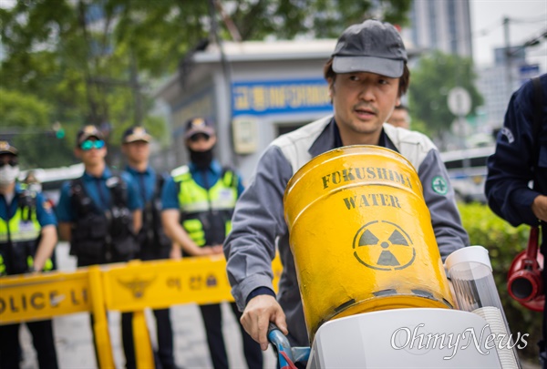 이제석 광고연구소 소장과 녹색연합 활동가가 7일 오전 서울 종로구 일본대사관 인근에서 후쿠시마 핵오염수 방류 반대하는 누구도 마실 수 없는 핵오염수 정수기 배달 퍼포먼스를 통해 '핵오염수 정수기'를 일본대사관으로 전달을 시도하고 있다. 