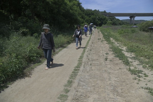 환경단체와 행정의 협치의 산물 흙길 산책길을 맨발로 걷고 있는 참가자들 