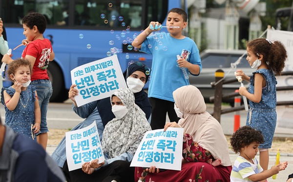 2022년 8월 21일 어린이들이 오후 서울 종로구 보신각 앞에서 열린 난민 신청자 보호 및 조속한 난민 심사 촉구 집회에서 비눗방울을 불며 놀고 있다.  