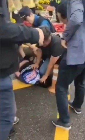 경찰이 지난 5월 30일 광양제철소 앞에서 시위를 벌이던 한국노총 노조원의 머리를 무릎으로 짓누른 채 진압하고 있다.