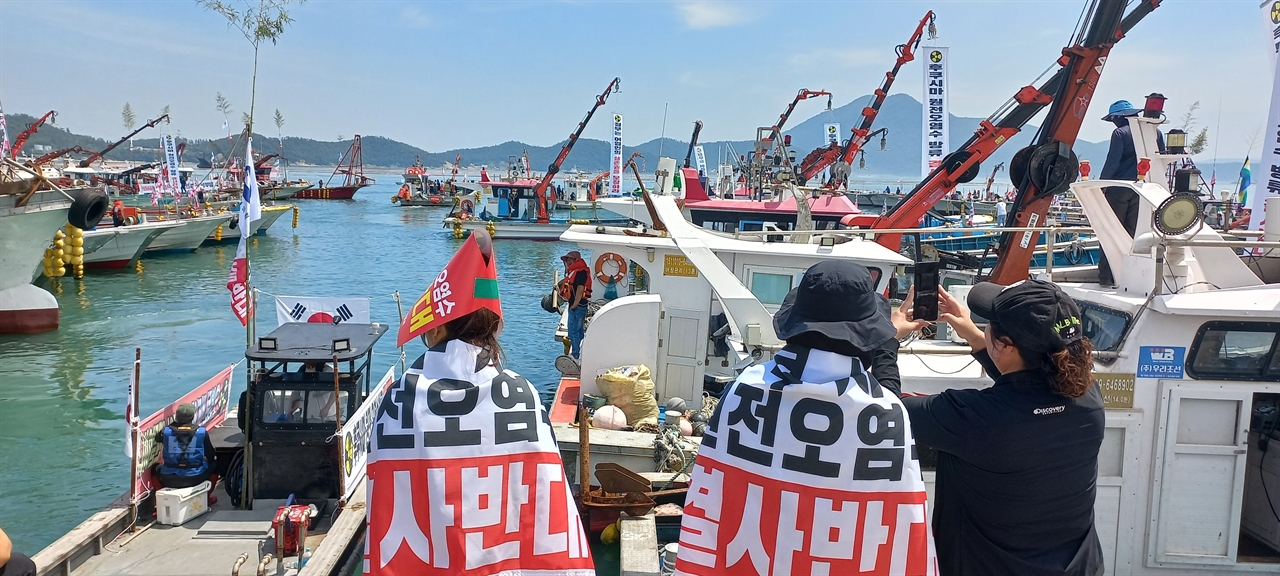 23일 후쿠시마 원전 방사능 오염수 해양 투기 반대 해상 시위를 위해 전라남도 완도항을 나서는 어선을 지켜보는 어민들.