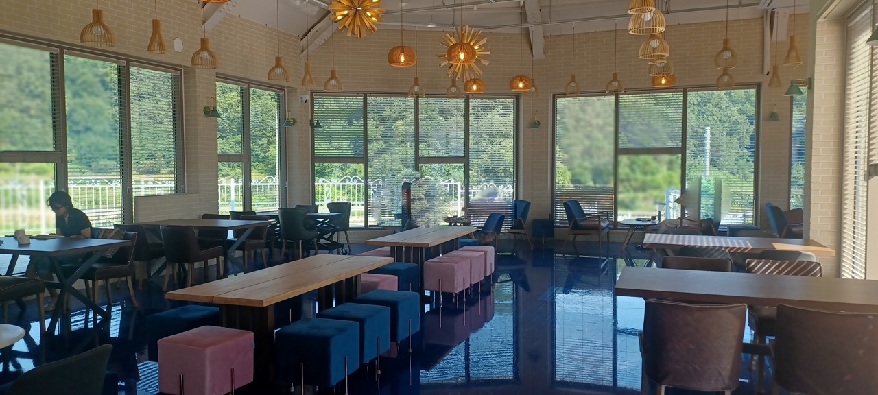 푸른 색 타일의 카페 바닥과 시원한 창밖 풍경이 인상적이다.