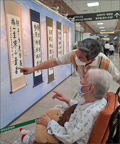 오희옥 지사가 아드님과 함께 서울중앙보훈병원 갤러리에 전시중인 적품을 둘러보고 있다.