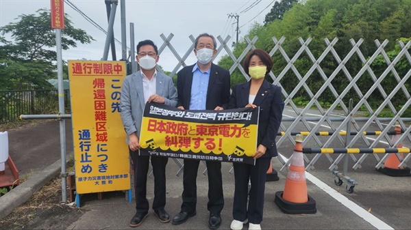 배진교 정의당 원내대표(사진 왼쪽), 핫토리 료이치 일본 사민당 간사장(사진 가운데), 이은주 정의당 원내수석부대표(사진 오른쪽)가 후쿠시마 원전사고 통행제한구역 앞에서 '일본정부와 도쿄전력 규탄한다' 퍼포먼스를 진행하고 있다.