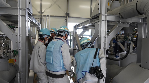 지난 26일 일본 정부 및 지자체 관계자들이 후쿠시마 제1 원자력 발전소 오염수 방출 설비 중 측정·확인용 설비로부터의 시료 채취에 입회해 있다. 
