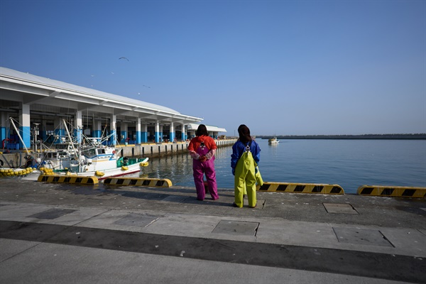 2023년 3월 8일 일본 후쿠시마현 소마시의 한 둑에서 어부들이 어선을 기다리고 있다. 