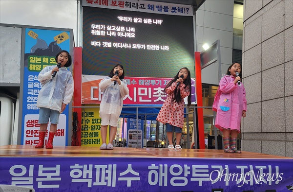  11일 저녁 대전 서구 둔산동 은하수네거리 KB국민은행 둔산갤러리아지점 앞에서 열린 '일본 핵폐수 해양투기 저지! 대전시민 촛불집회'. 사진은 어린이평화합창단 '하늘고래'의 노래공연 장면.