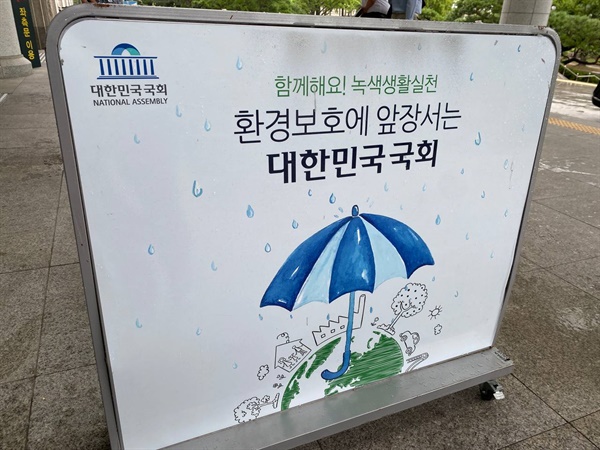 국회의원회관 출입구에 설치된 우산빗물제거기. 쓰여진 문구가 초라하기만 하다.