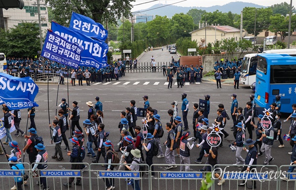 노동자들이 윤석열 대통령이 이용하는 대통령실 차량 출입구 앞을 지나 행진하고 있다.