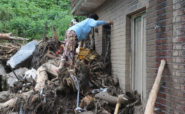 16일 오전 경북 예천군 감천면 벌방리에서 한 주민이 산사태에 휩쓸린 집을 살펴보고 있다.