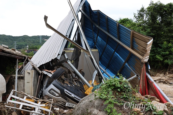 지난 13일부터 집중 호우로 산사태가 나 피해를 입은 경북 예천군 감천면 벌방리의 한 주택 창고가 무너져 내리면서 창고 안에 있던 승용차가 뒤집어져 있다.