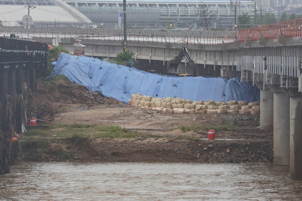 지난 18일 오후 충북 청주시 미호천교 아래에 임시제방이 쌓여있다. 지난 15일 폭우로 미호강 제방이 무너지며 강물이 궁평2지하차도를 덮쳐 24명의 사상자가 발생했다.