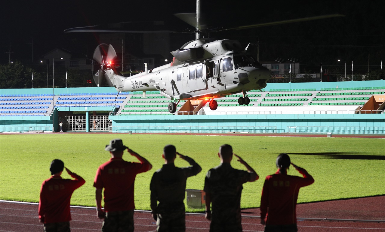 20일 오전 0시 47분께 경북 예천스타디움에서 수색 중 실종됐다가 숨진 채 발견된 해병 장병을 태운 헬기가 전우들의 경례를 받으며 이륙하고 있다.