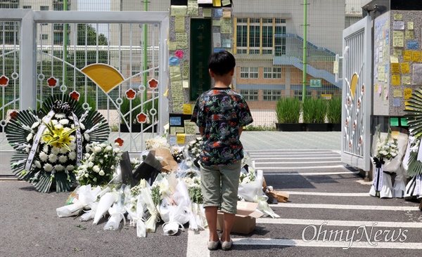 시민들이 지난 20일 오전 서울 서초구 S초등학교 앞에서 1학년 교사의 사망에 가슴 아파하며 국화꽃과 위로의 메시지를 놓고 가고 있다.