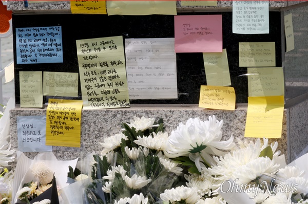 시민들이 지난 7월 20일 오전 서울 서초구 S초등학교 앞에서 1학년 교사의 극단적 선택에 가슴 아파하며 국화꽃과 위로의 메시지를 놓고 가고 있다.