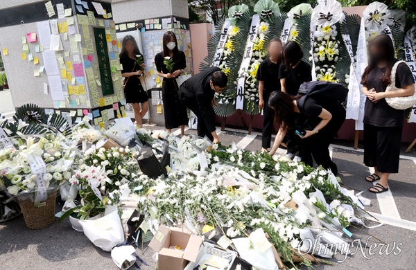 시민들이 20일 오후 서울 서초구 S초등학교 앞에서 1학년 교사의 죽음에 가슴 아파하며 애도의 메시지와 국화꽃을 놓고 있다.