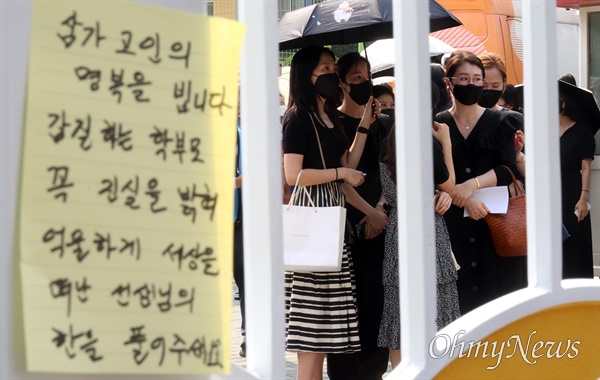 시민들이 20일 오후 서울 서초구 S초등학교 앞에서 1학년 교사의 죽음에 가슴 아파하며 교내 체육관에 추모공간 마련을 요구하고 있다.