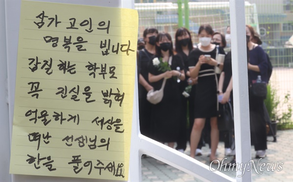 시민들이 지난 20일 오후 서울 서초구 S초등학교 앞에서 1학년 교사의 죽음에 가슴 아파하며 교내 체육관에 추모공간 마련을 요구하고 있다.
