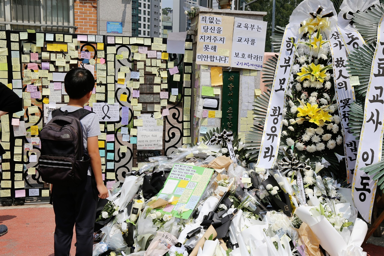 초등학교 교사가 극단적 선택을 한 서울 S초등학교 앞에서 한 초등학생이 교문에 붙은 추모글을 바라보고 있다.  